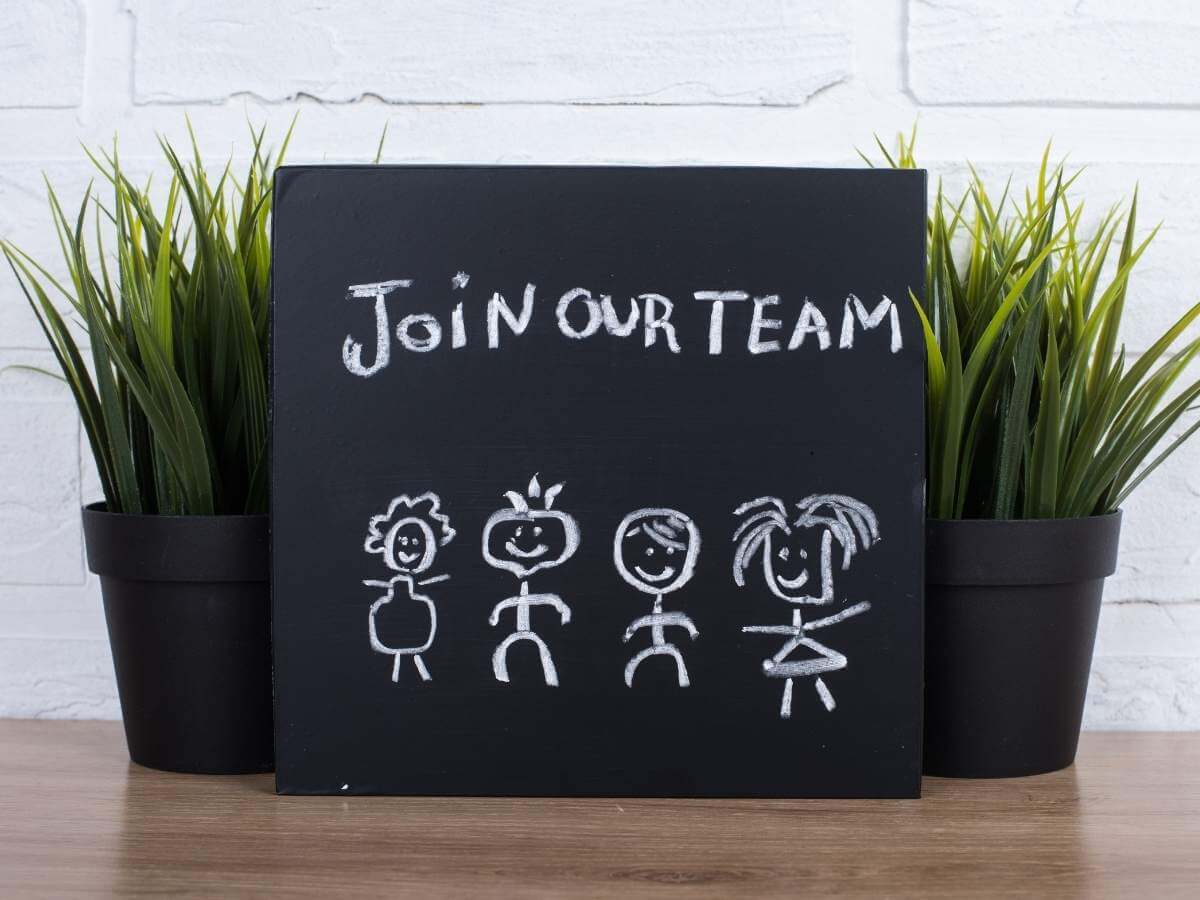 Join our team text written on a small blackboard propped up against potted plants