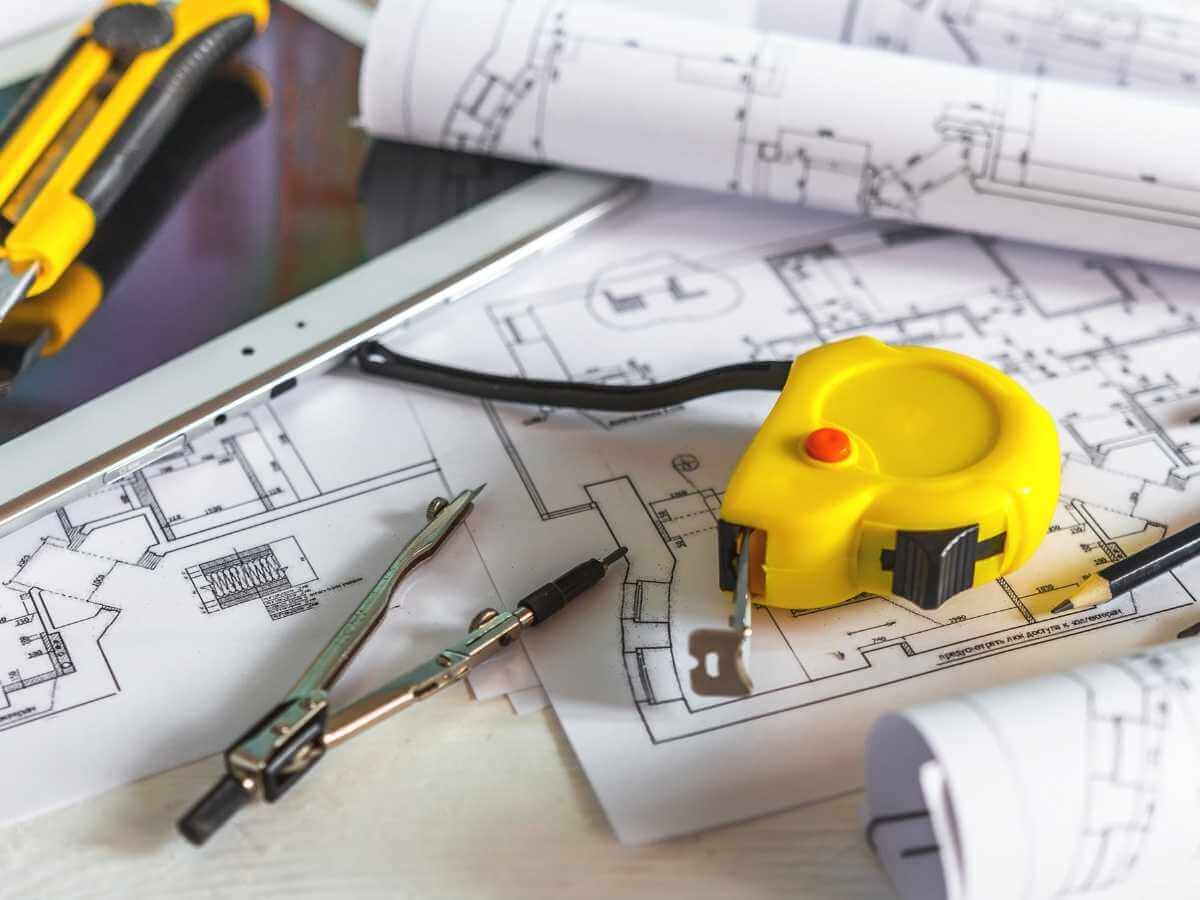 Site plans and tools spread out over a desk