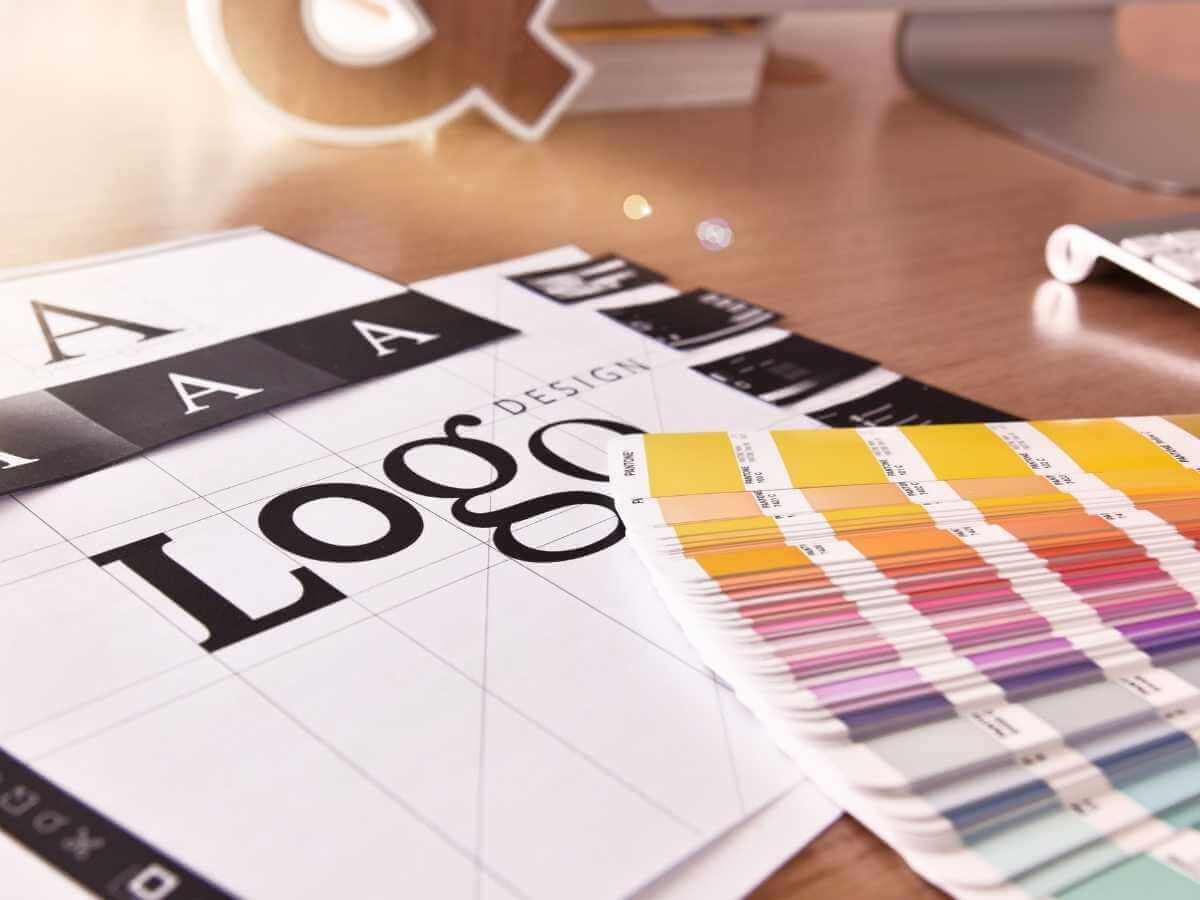 Colour charts and logo designs scattered over a desk