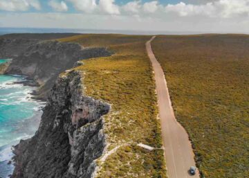 What is a car fringe benefit | Image of a car driving along a deserted road along rugged Australian coastline.