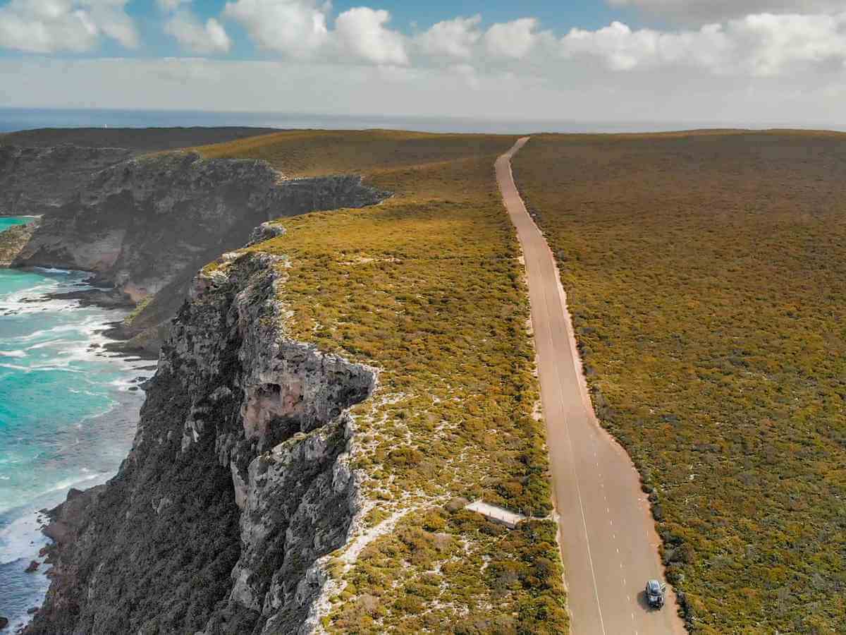 What is a car fringe benefit | Image of a car driving along a deserted road along rugged Australian coastline.