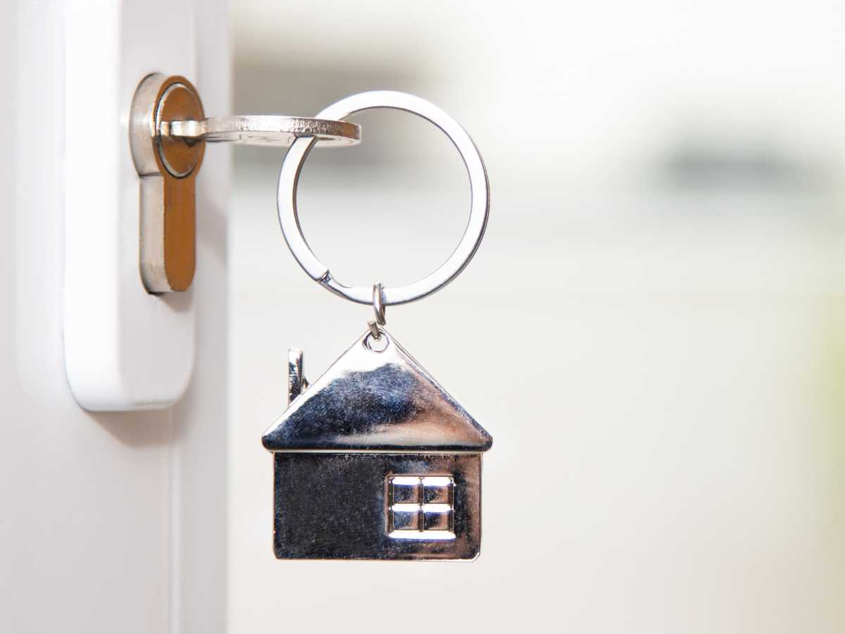Home Guarantee Scheme - image of a key in front door lock with a silver house key ring dangling