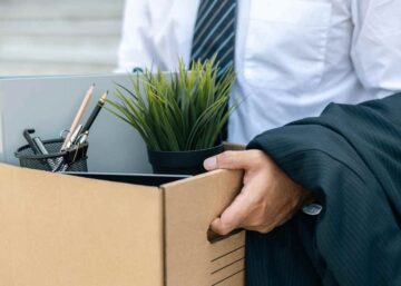 Getting the redundancy process right | A male office worker leaves his job with a cardboard box containing personal items