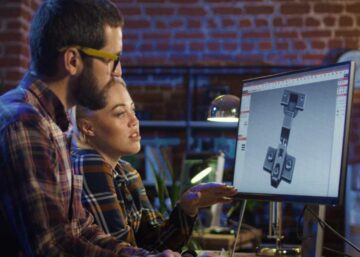 Digital games tax offset | A young man and woman sitting at computer and working on creating video game graphics.